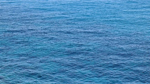 Cenova, Italy- 27 Temmuz 2022: mavi denizin panoraması, suyun üzerindeki ışık, okyanus gündoğumu. Kış günlerinde küçük dalgalar. Temiz gökyüzü suya yansıyor.