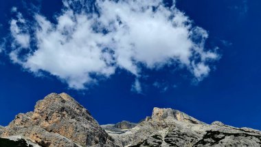 Val Badia, Italy-July 18, 2022: The italian Dolomites behind the small village of Corvara in summer days with beaitiful blue sky in the background. Green nature in the middle of the rocks.