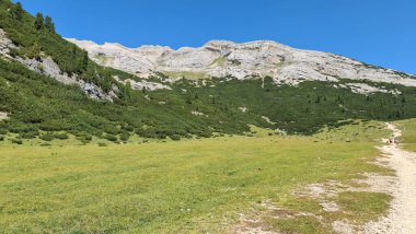 Val Badia, Italy-July 18, 2022: The italian Dolomites behind the small village of Corvara in summer days with beaitiful blue sky in the background. Green nature in the middle of the rocks.