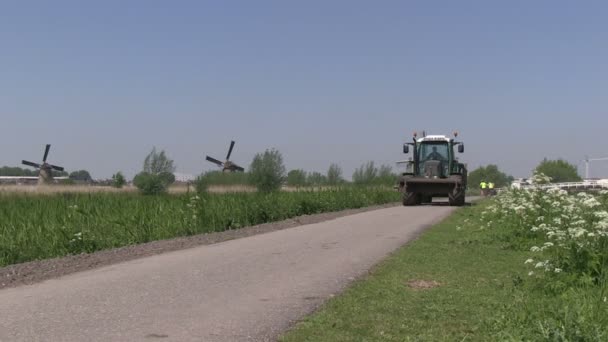 Тракторные и голландские ветряные мельницы возле Киндердейка, Нидерланды — стоковое видео
