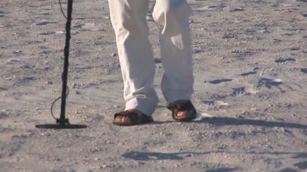 Senior man walks on St. Pete's beach with a metal detector — Stock Video