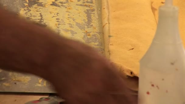 Mann streift Blech von Einband — Stockvideo
