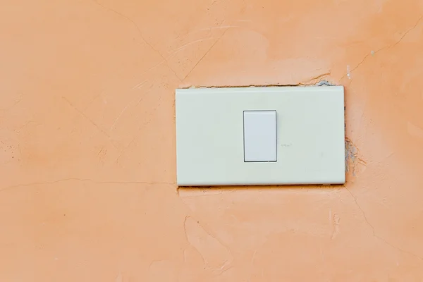 Electrical white rocker light switch on pastel orange wall — Stock Photo, Image