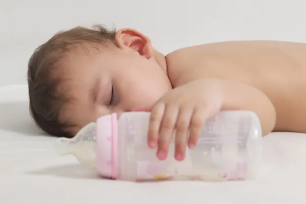 Μωρό που κοιμάται μετά την κατανάλωση εδώ μπουκάλι Φωτογραφία Αρχείου