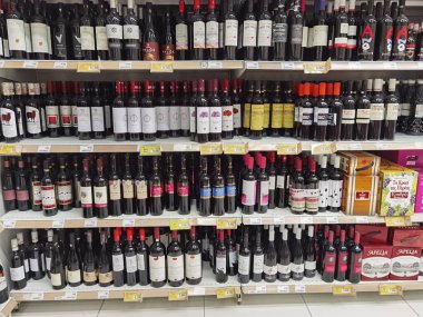 Şarap mahzeni süpermarkette raflarda bir sürü şişe ve şarap var.