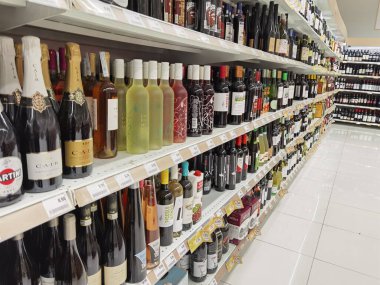 Şarap mahzeni süpermarkette raflarda bir sürü şişe ve şarap var.