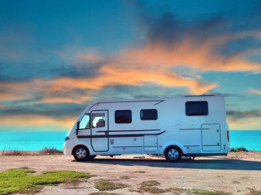 Sonbahar mevsiminde kumsaldaki karavan arabası güneşli günde mavi gökyüzü