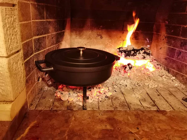 Gövde fırın tavası güveci yemek pişirirken şöminede.