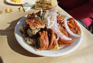 Yunanca geleneksel kokoretsi eti tabakta soğan ve keklikotu ile birlikte. 