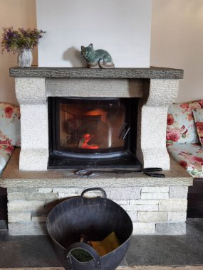 Geleneksel olarak taştan yapılmış koruyucu camlı şömine.