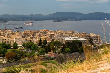 İlkbahar manzaralı Corflu şehri Yunan İyonio denizinde yeşil ağaçlar taşıyor. 