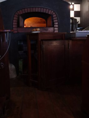 Pizzalar fırında sıcak, odunlar ve şöminede taze pişmiş yemekler.