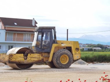 Çakıl yolunda büyük eski bir silindir.