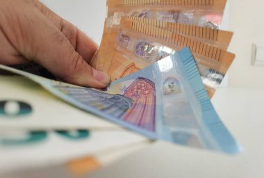 hand  gives money euros pile banknotes in white background