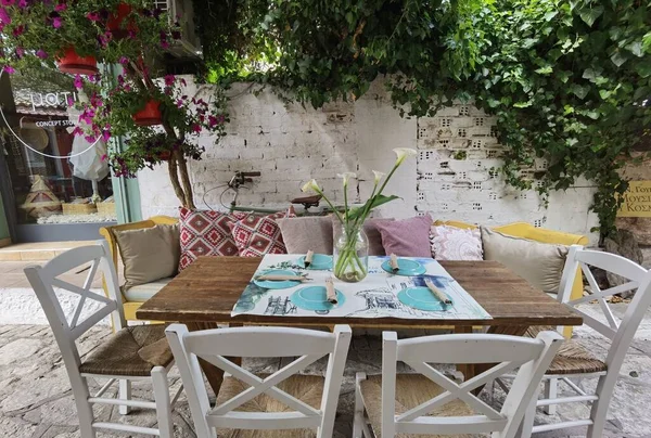 Greece Preveza şehrinin sokaklarındaki saksılarda masalarda kırmızı güller.