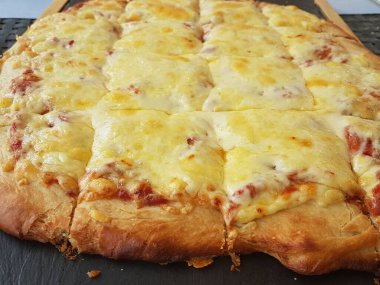Siyah ahşap masa yemeği arka planında peynirli pizza.