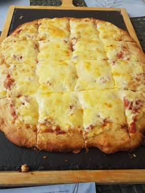 Siyah ahşap masa yemeği arka planında peynirli pizza.