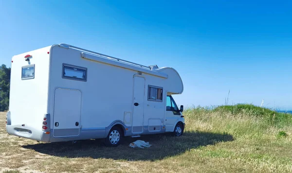 caravan car and dog parked on the grass by the sea in greece hoidays travelling