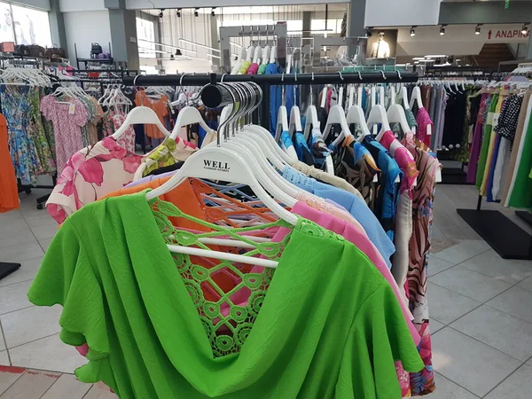 clothes on hangers dresses summer collection vivid colors in a shop