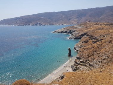 greece andros island beach called tis grias to pidima, rock high in the sea in summer season