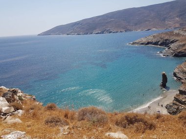 greece andros island beach called tis grias to pidima, rock high in the sea in summer season