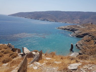 greece andros island beach called tis grias to pidima, rock high in the sea in summer season