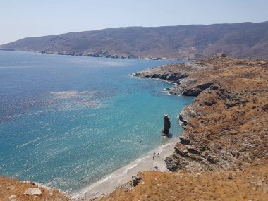 greece andros island beach called tis grias to pidima, rock high in the sea in summer season