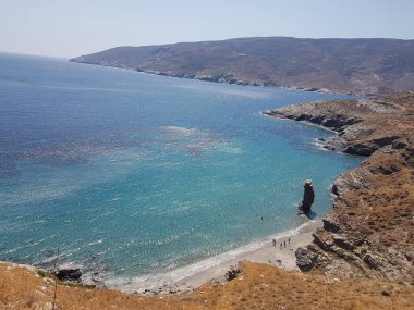 greece andros island beach called tis grias to pidima, rock high in the sea in summer season