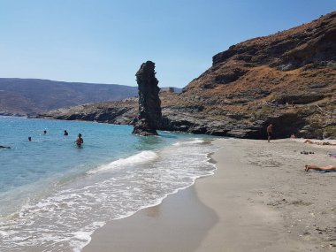 greece andros island beach called tis grias to pidima, rock high in the sea in summer season