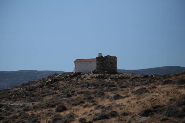 greece andros island beach called tis grias to pidima, rock high in the sea in summer season