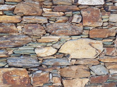 wall of natural rocks in andros island greece 