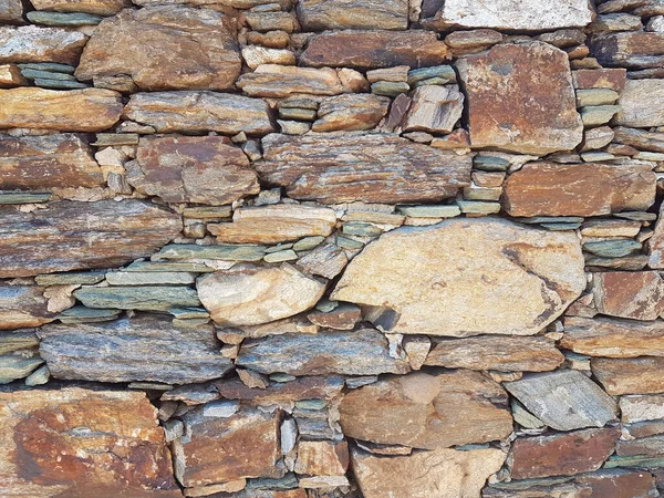 wall of natural rocks in andros island greece 