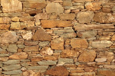wall of natural rocks in andros island greece 
