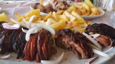 meat called kokoretsi in a plate with potatoes and onion greek kitchen food