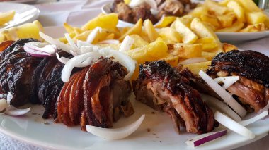 meat called kokoretsi in a plate with potatoes and onion greek kitchen food