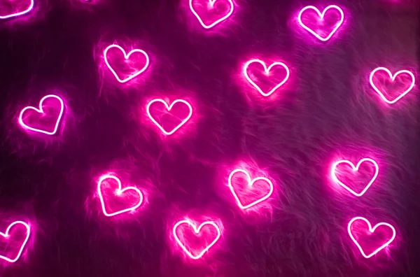 Neon pink heart on white fur. Valentines day background — Stock Photo, Image