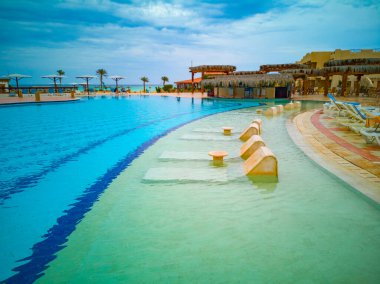 Yüzme havuzu, Mısır otelinde palmiyeler ve deniz manzaralı bir bölge. Yüksek kalite fotoğraf