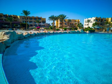 Yüzme havuzu, Mısır otelinde palmiyeler ve deniz manzaralı bir bölge. Yüksek kalite fotoğraf