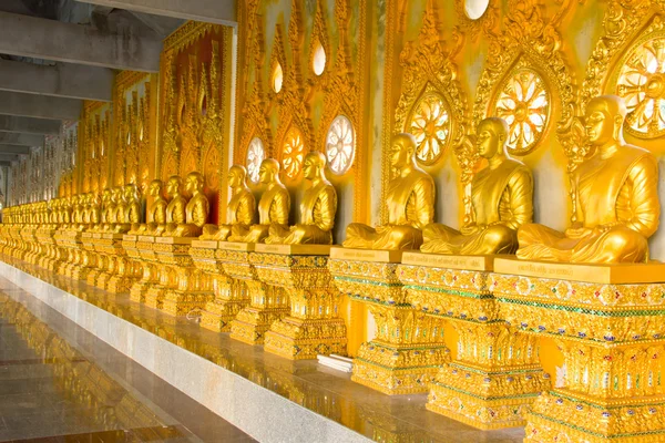Ряд золотых буддийских статуй монаха в тайском храме Чаймонгхол — стоковое фото