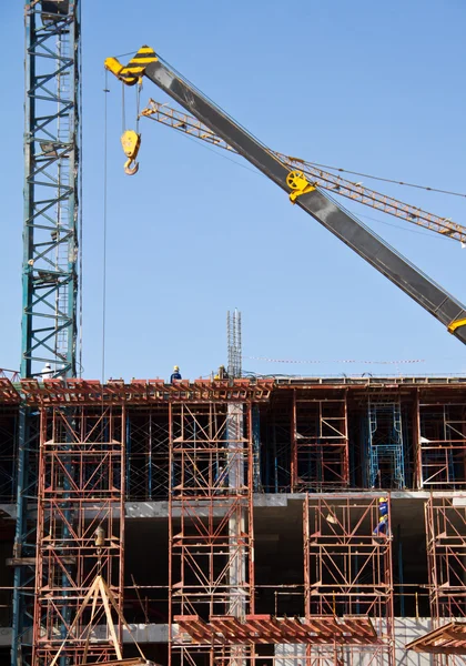 Crane and workers at construction site against blue sky. Thailand — Stock Photo, Image