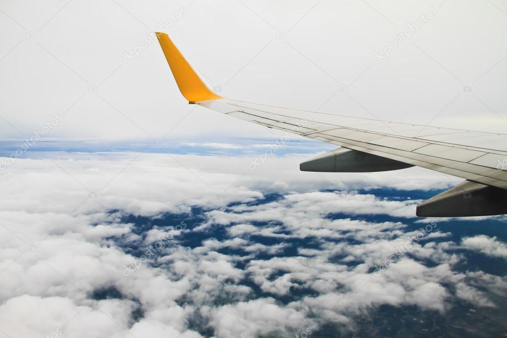 Wing of the plane on sky background - view from the window of a plane