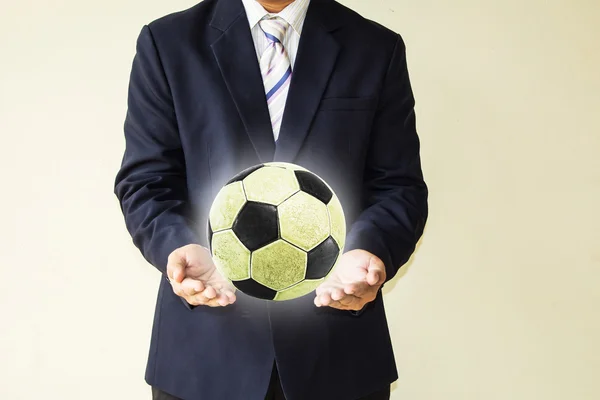 Hombre de negocios sosteniendo una pelota de fútbol —  Fotos de Stock