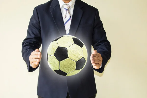 Hombre de negocios sosteniendo una pelota de fútbol —  Fotos de Stock