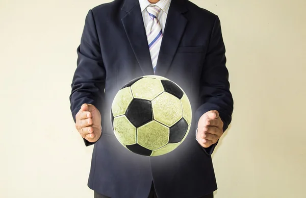 Hombre de negocios sosteniendo una pelota de fútbol —  Fotos de Stock