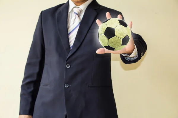 Hombre de negocios sosteniendo una pelota de fútbol —  Fotos de Stock