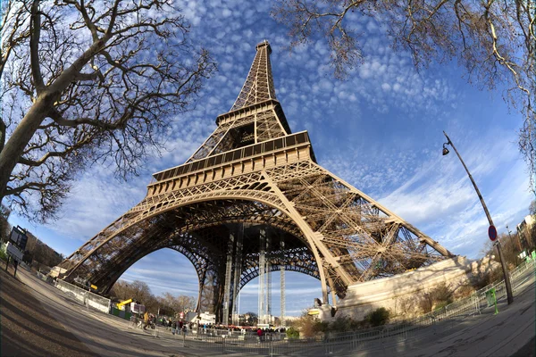 Эйфелева башня в Париже с зеленой травой, голубым небом и белыми облаками — стоковое фото