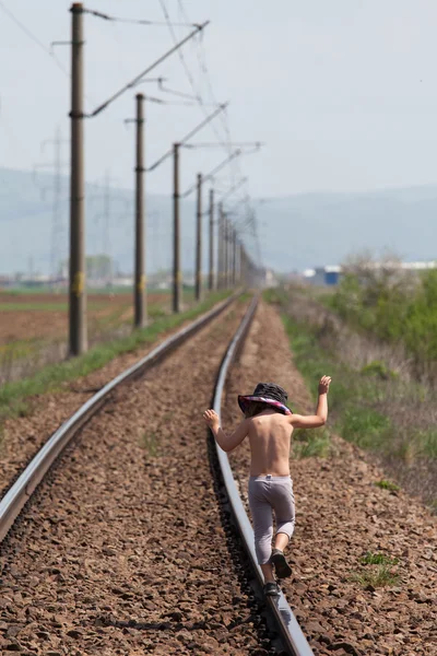 Müzik ve raylı tren üzerinde yürüyen çocuk — Stok fotoğraf