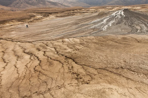 Person walking on mud volcanoes — Stock Photo, Image