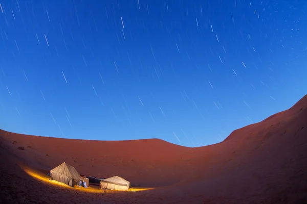 Acampamento iluminado no deserto do Saara à noite com estrelas em movimento — Fotografia de Stock