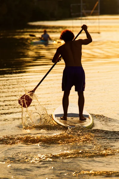 Siluet manusia paddleboarding saat matahari terbenam, Florence sungai, Ital — Stok Foto